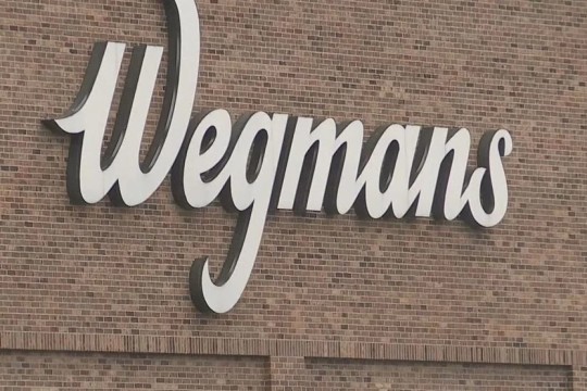 Wegmans store logo on a brick building.