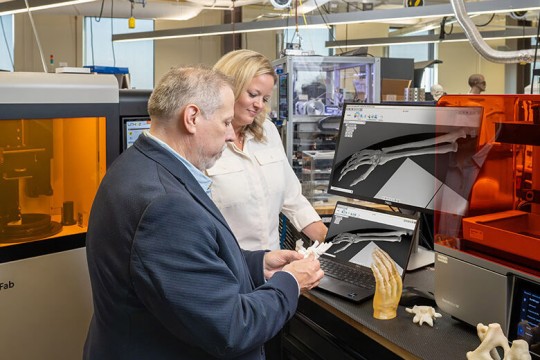 a man and woman stand in a research lab.
