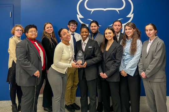 Group of student standing, holding an award