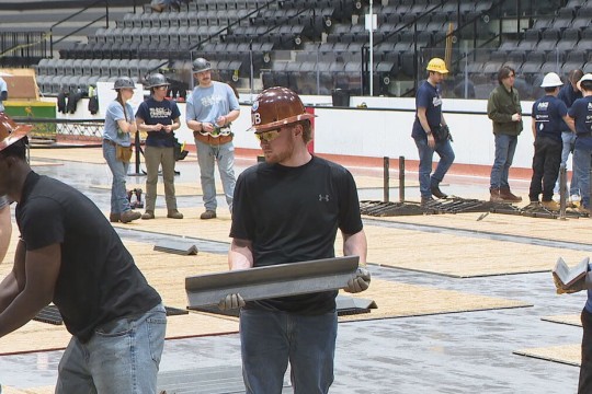 civil engineering students hold pieces of concrete to build a canoe