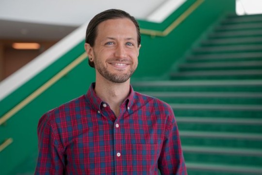 a portrait of Andy Head standing in the lobby of the new RIT Performing Arts Center