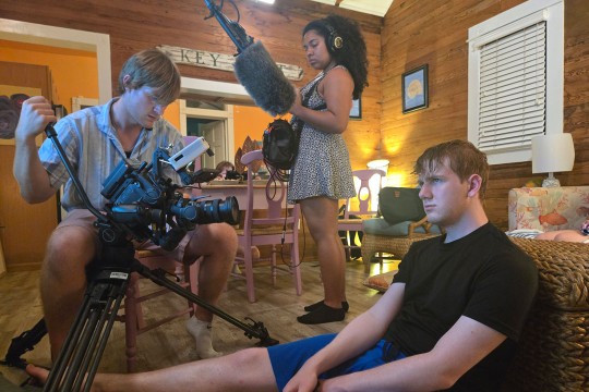 'students film a scene in a cabin'