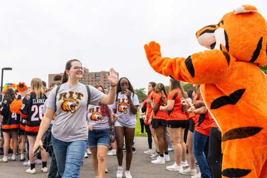 'A first-year student gives RITchie a high-five during Tiger Walk '