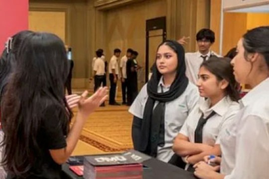 'students speak to representatives at a job fair in Dubai'