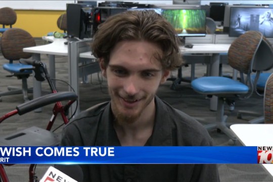 a young man sit in acomputer lab speaking about his make a wish wish.