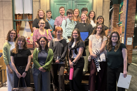 A group of RIT MST candidates in front of a Sesame Street set at the Strong National Museum of Play.