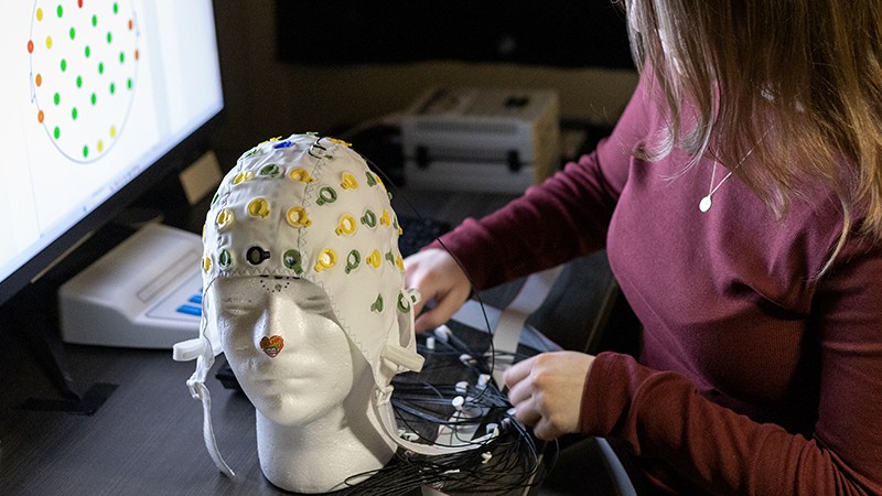 A neuroscience student using an EEG cap to record brain activity