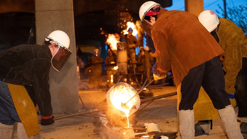 Students participate in an iron pour.