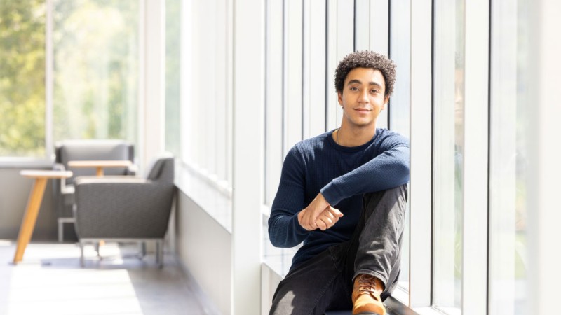student sitting on windowsill