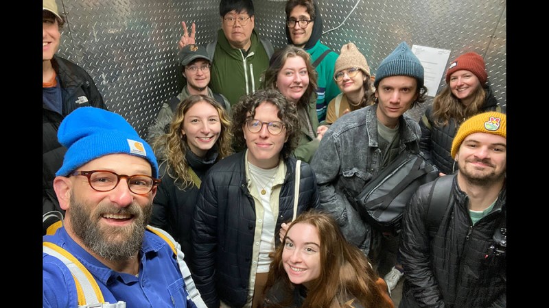 12 people gathered for a photo in a tight space.