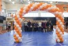 an arch of orange and white balloons