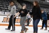 three people ice skating.