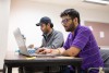 two students working on laptop computers.