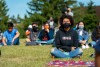 Students sitting in lawn watching presentation wearing masks