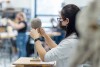 Student working with clay model and wearing mask