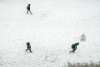 students walk on snow covered path, shot from above, showing footprints
