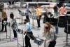 students in a row playing steel drums.