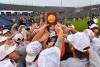 men's lacrosse players holding up a trophy.