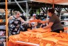 people in a tent handing a resuable bag to an RIT employee.