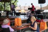 two women sitting at a picnic bench listening to a band.