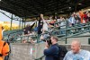 crowd of people at a baseball game try to catch a foul ball.