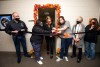 six people participating in a ribbon cutting.