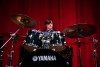 student playing drums on stage.