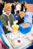 two volunteers in an assembly line filling bags with dry ingredients.