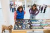 two people looking at a display of political buttons and bumper stickers from the 1960s.