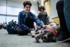 two students petting a bullmastiff dog.