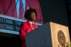 college student speaking on a stage at a podium.