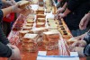 several volunteers at a long table assembling peanut butter and jelly sandwiches.
