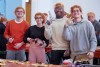 four college students wearing orange hairnets posing for a photo.