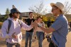 two college students clapping hands in a special handshake.