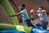 two college students throwing basketballs in an inflatable hoop set.