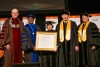 Pattie Moore is shown on stage holding her honorary degree