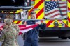 A firefighter attaches a flag to be raised during the 9 11 Vigil 