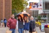 A student stands with her parents and grandmother on campus.