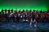 Orchestra plays as two dancers perform on stage