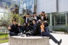Graduates celebrate around a tiger statue.