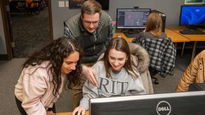 Alan Gasek instructs students while they work on a computer.
