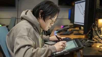 A student draws on a tablet.