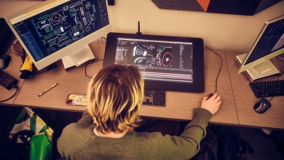 An overhead view of a student looking/working at a Cintiq.