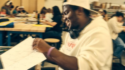 An RIT Foundations student holds a piece of paper.