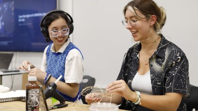 Two students smile as they work on Charrette projects.