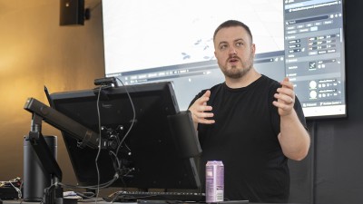 Faculty Aaron Powell at a computer station teaching.
