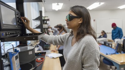 Student looking at equipment studying light 