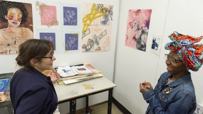 A visiting artist talks with a student in the painting studios.