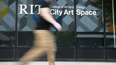 A person walks in front of RIT City Art Space.