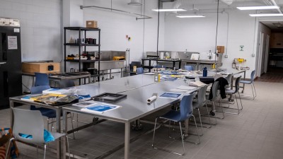 a large metal table in a workspace, with chairs around it.